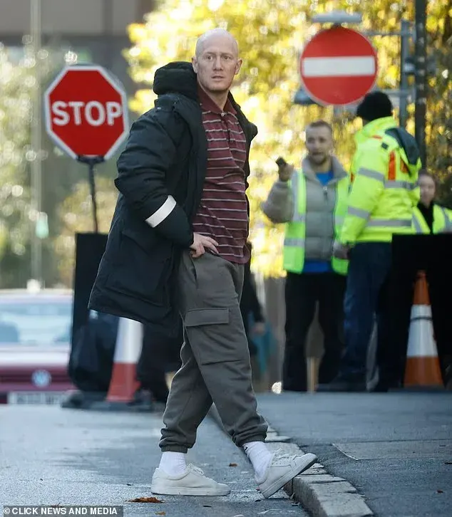 მეთიუ ტრევანიონი დიდი ზომის შავი პალტოთი BBC-ის დრამის სცენების გადაღებებს შორის შესვენებისას.